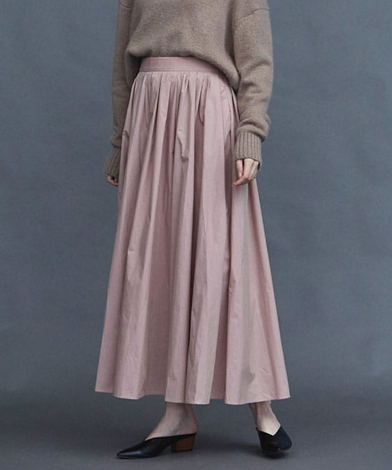 ランダムタックフレアースカートのダスティピンクを着用している女性の写真