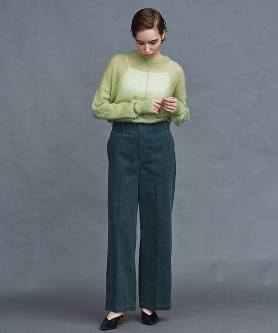 コーデュロイストレートパンツのグリーンを着用している女性の写真