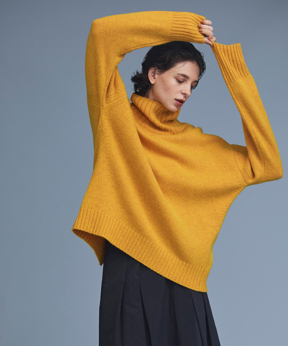 バックシームタートルニットを着用している女性の写真