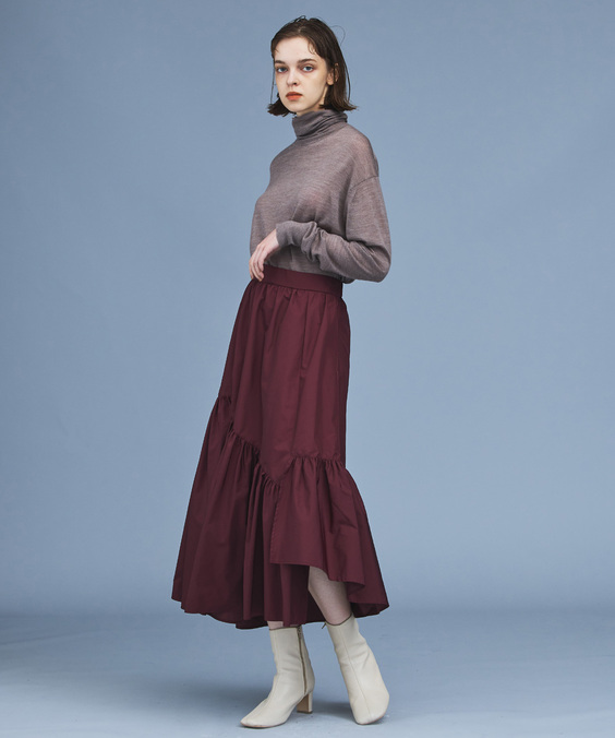 アシンメトリティアードスカートを着用している女性の写真