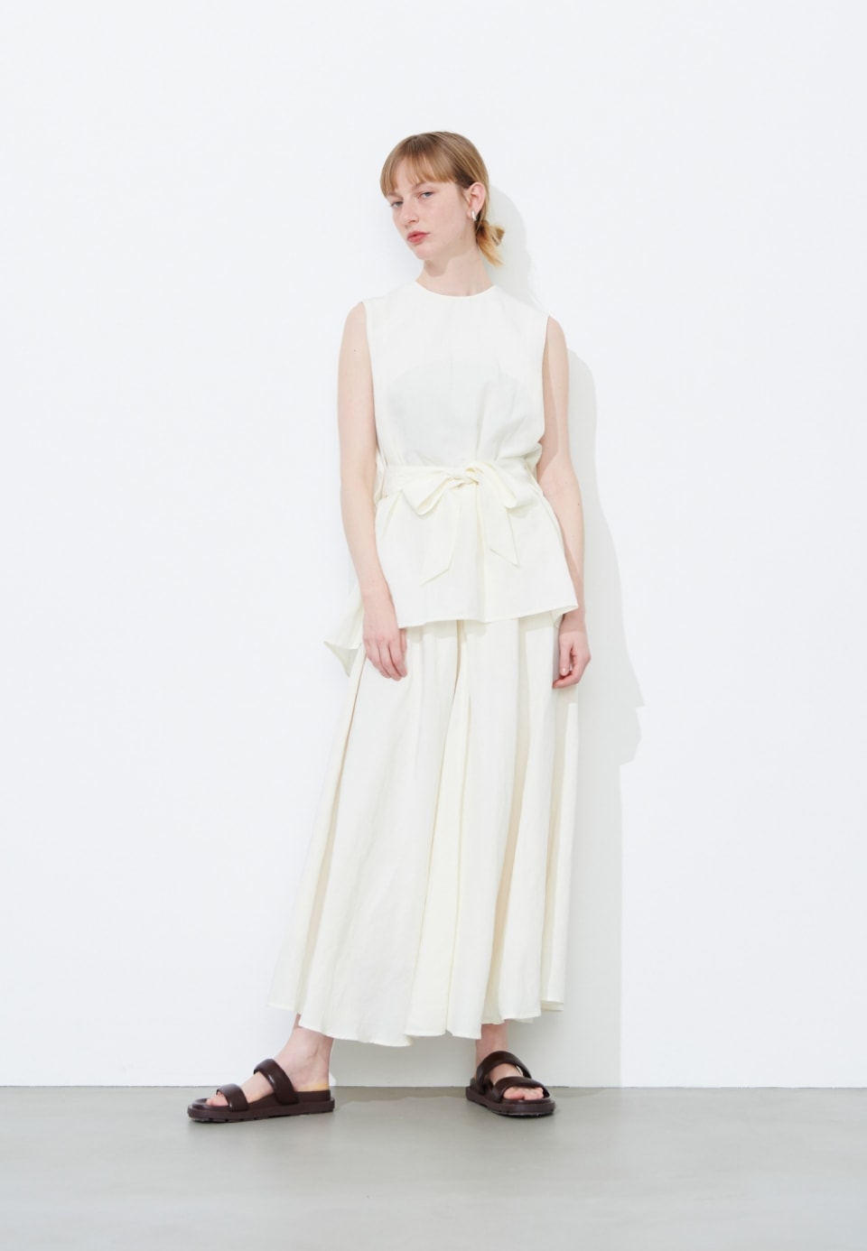 LINEN RAYONブラウスとLINEN RAYONフレアスカートを着用している女性モデルの写真