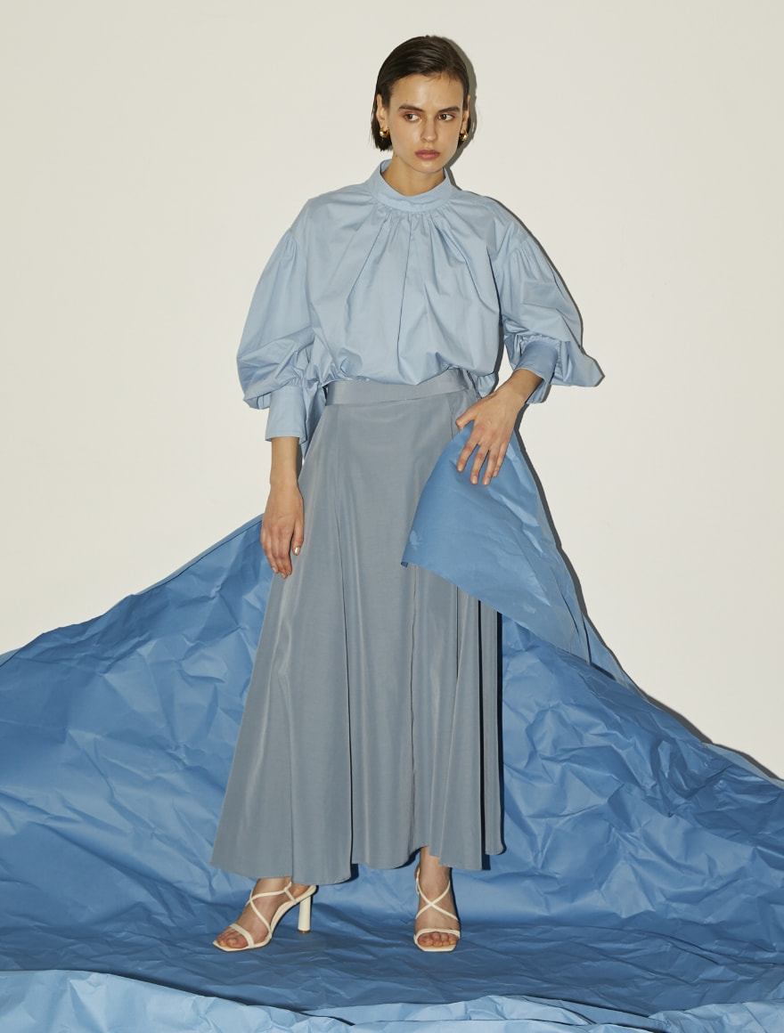 ボリュームスリーブブラウス、サイドフレアスカートを着用しているモデルの写真
