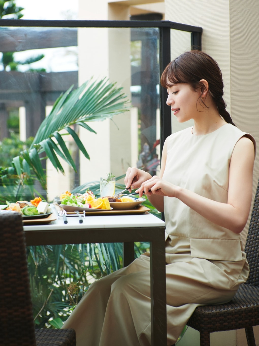 オールインワンを着用した女性がレストランで食事をしている写真