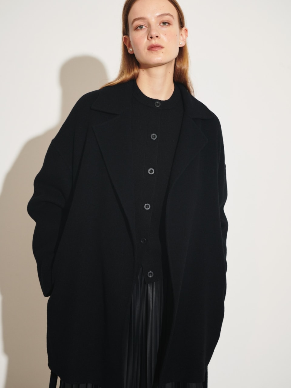 ベルテッドミドル丈リバーコート（ブラック）を着用した女性の上半身の写真