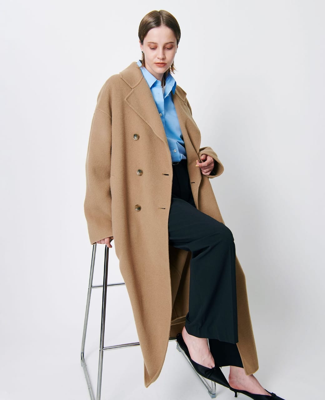 キャメルのダブルロングリバーコートを着用している女性の写真