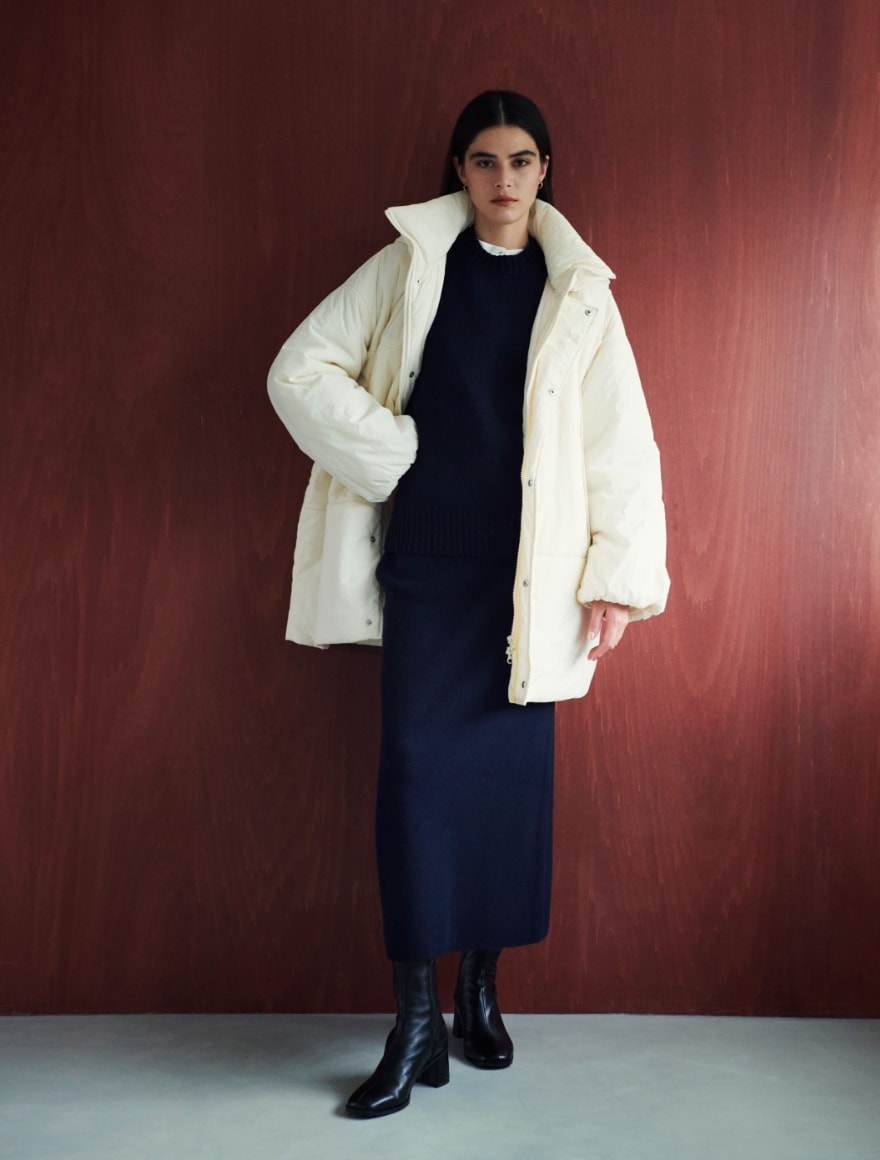 モンスターパーカー中綿コートとウールモックネックプルオーバーとウールニットスカートを着用した女性の写真１
