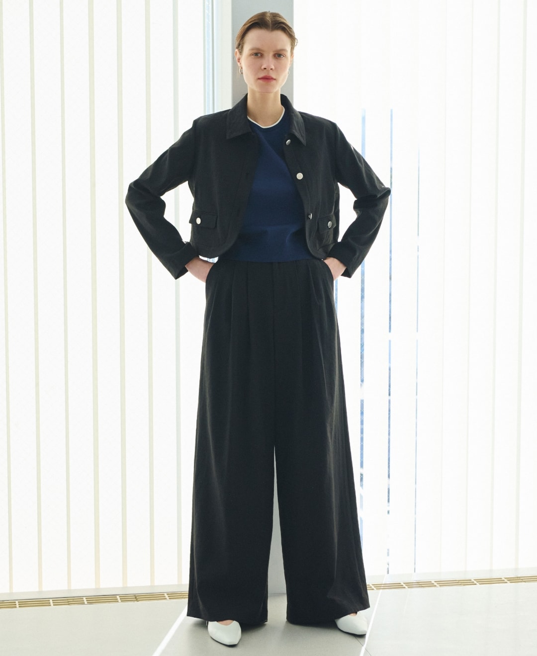 ジャケットとトップスとパンツとシューズを着用した女性の写真１