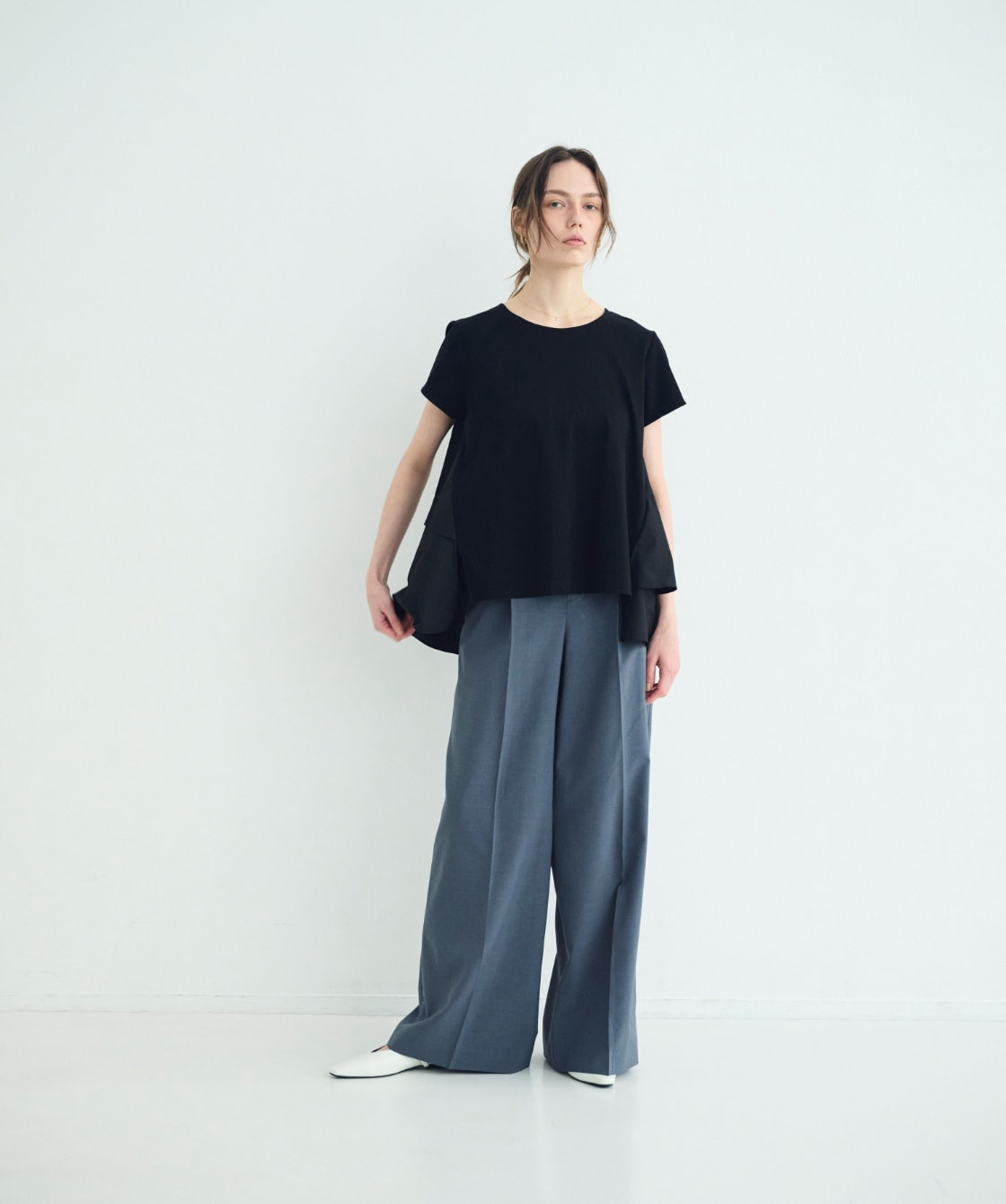 トップス、パンツ、シューズを着用した女性