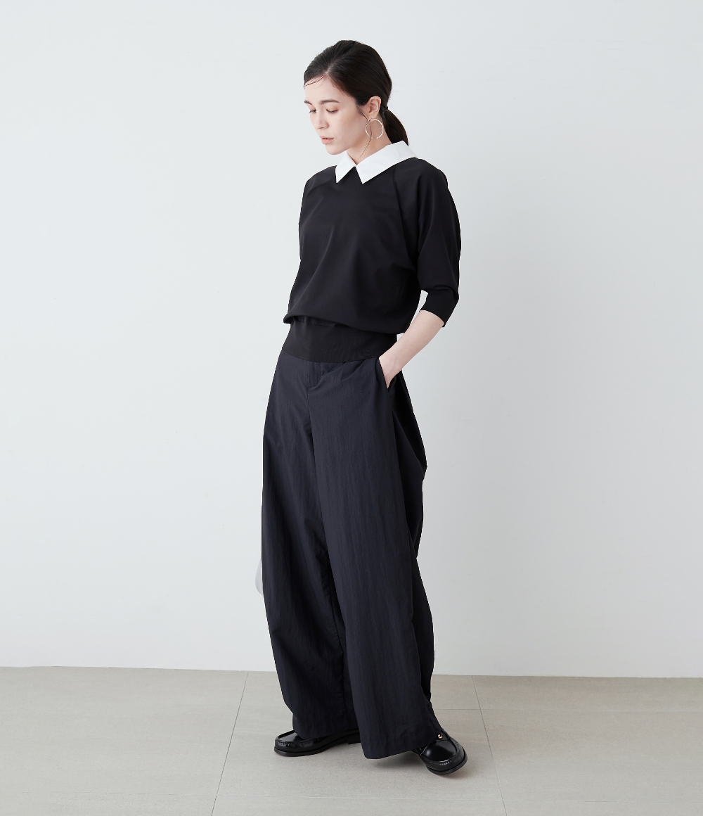 ブラックのニットとブラックのバレルパンツを着用した女性の画像--2