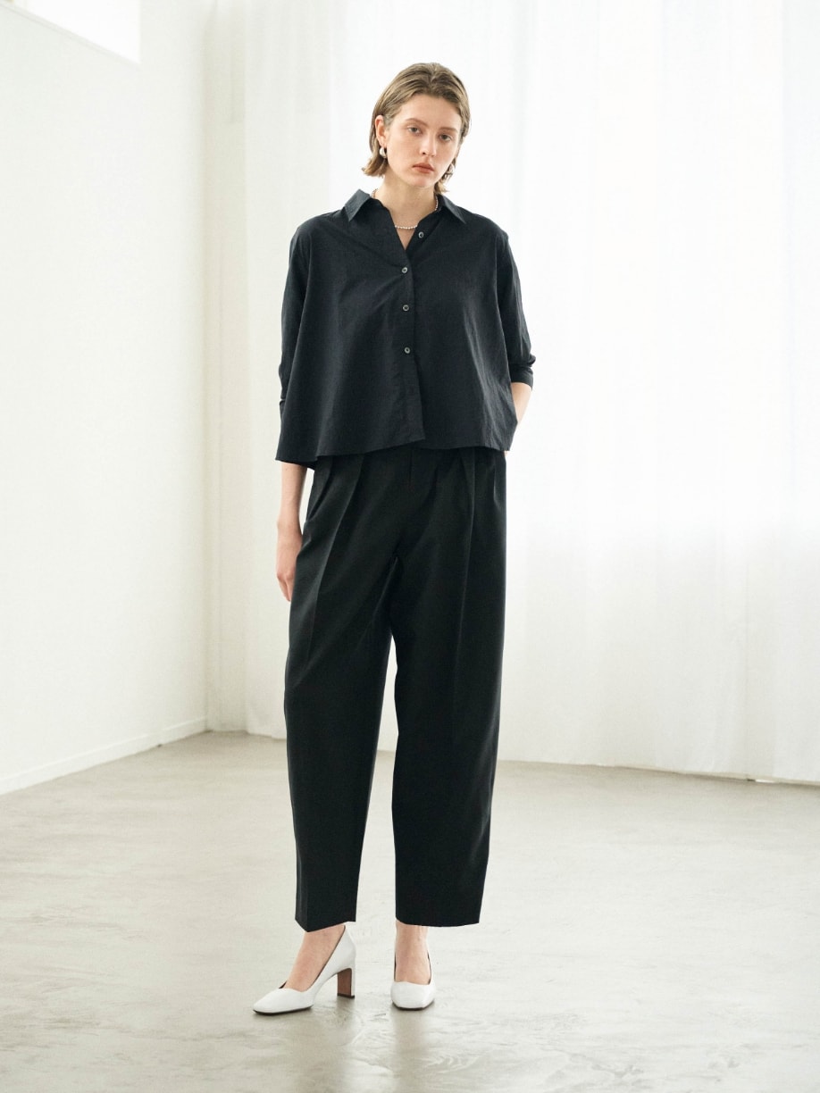 シャツとパンツとネックレスを着用した女性