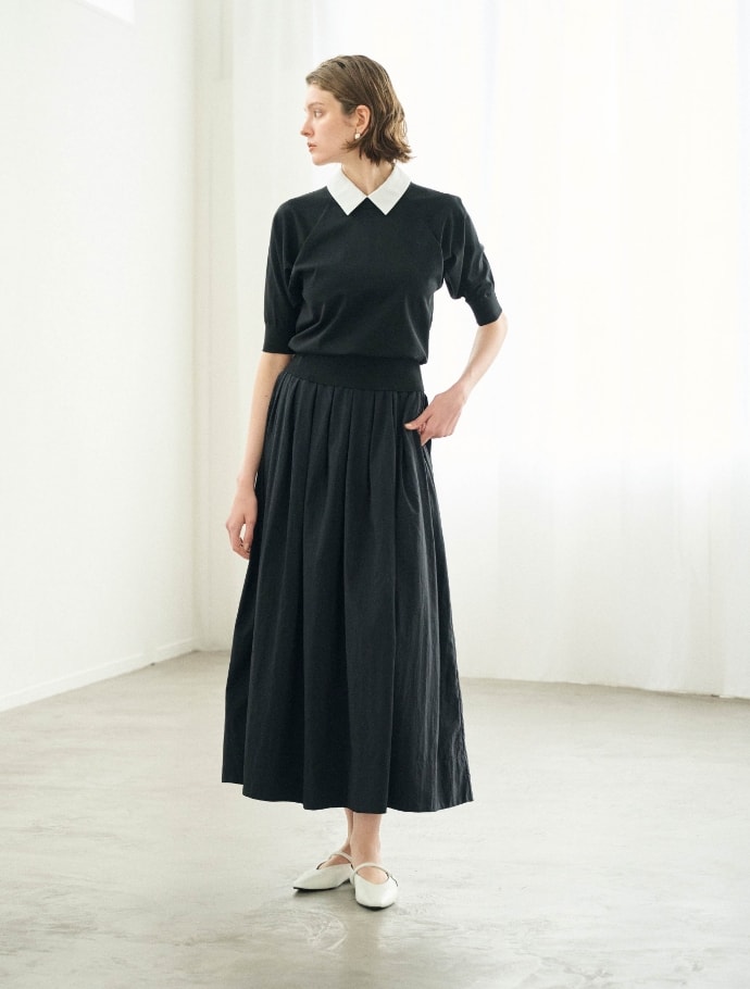 ニットとスカートとピアスを着用した女性