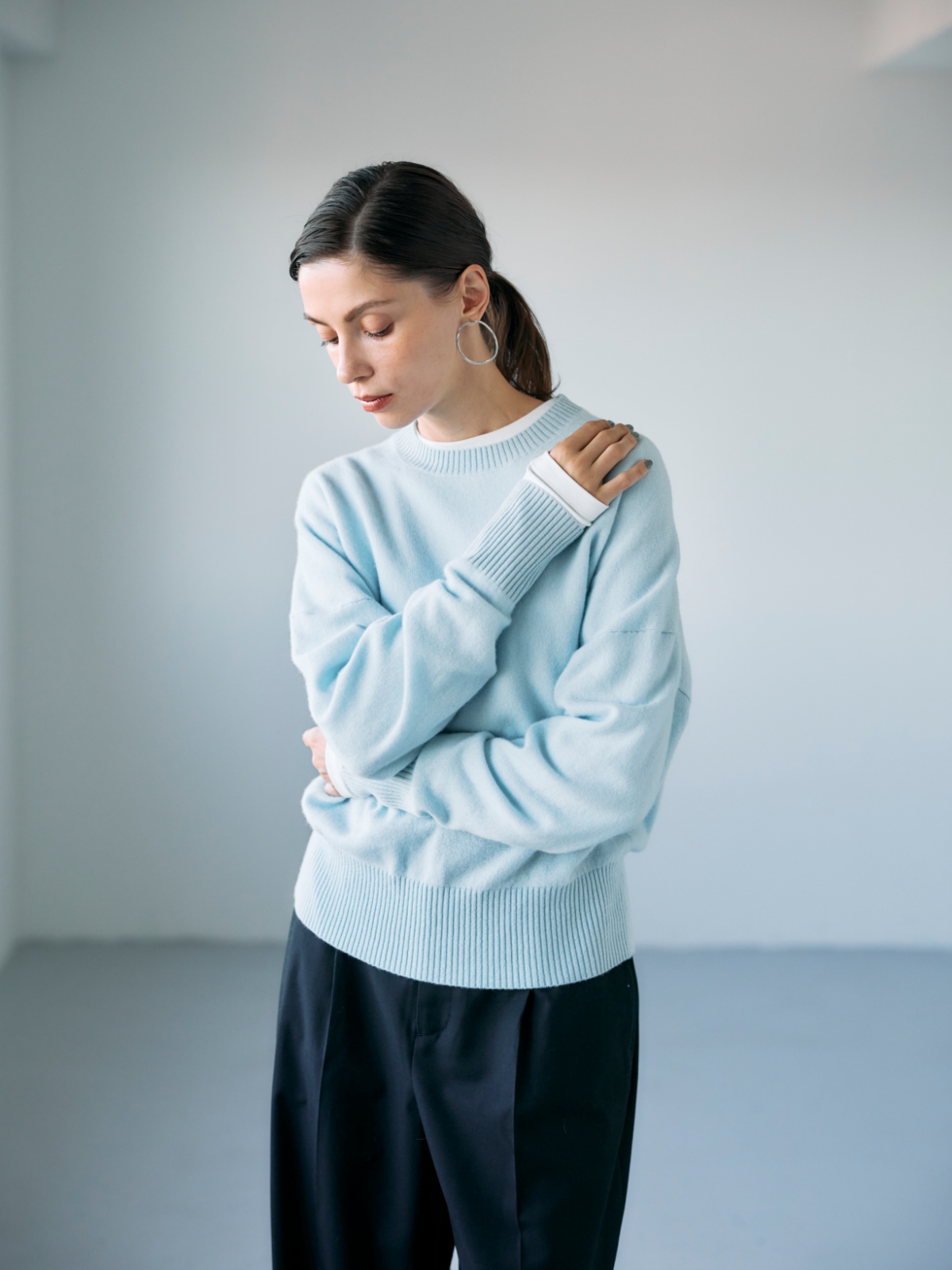 サックスの【CASHMERE100%】カシミヤクルーネックニット・オフホワイトのマルチファンクションボトルネックトップス・ブラックのウールライクソフトカーブパンツを着用した女性の画像--1