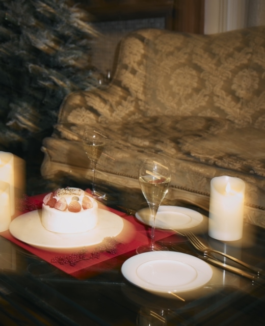 クリスマスケーキとシャンパンが並んだテーブルの手ぶれ風写真