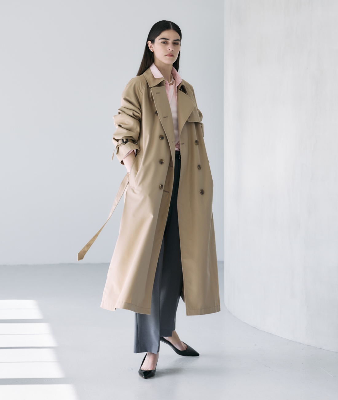 ベージュのロングトレンチコート・ピンクのシャツ・グレーのパンツを着用している女性の画像--3