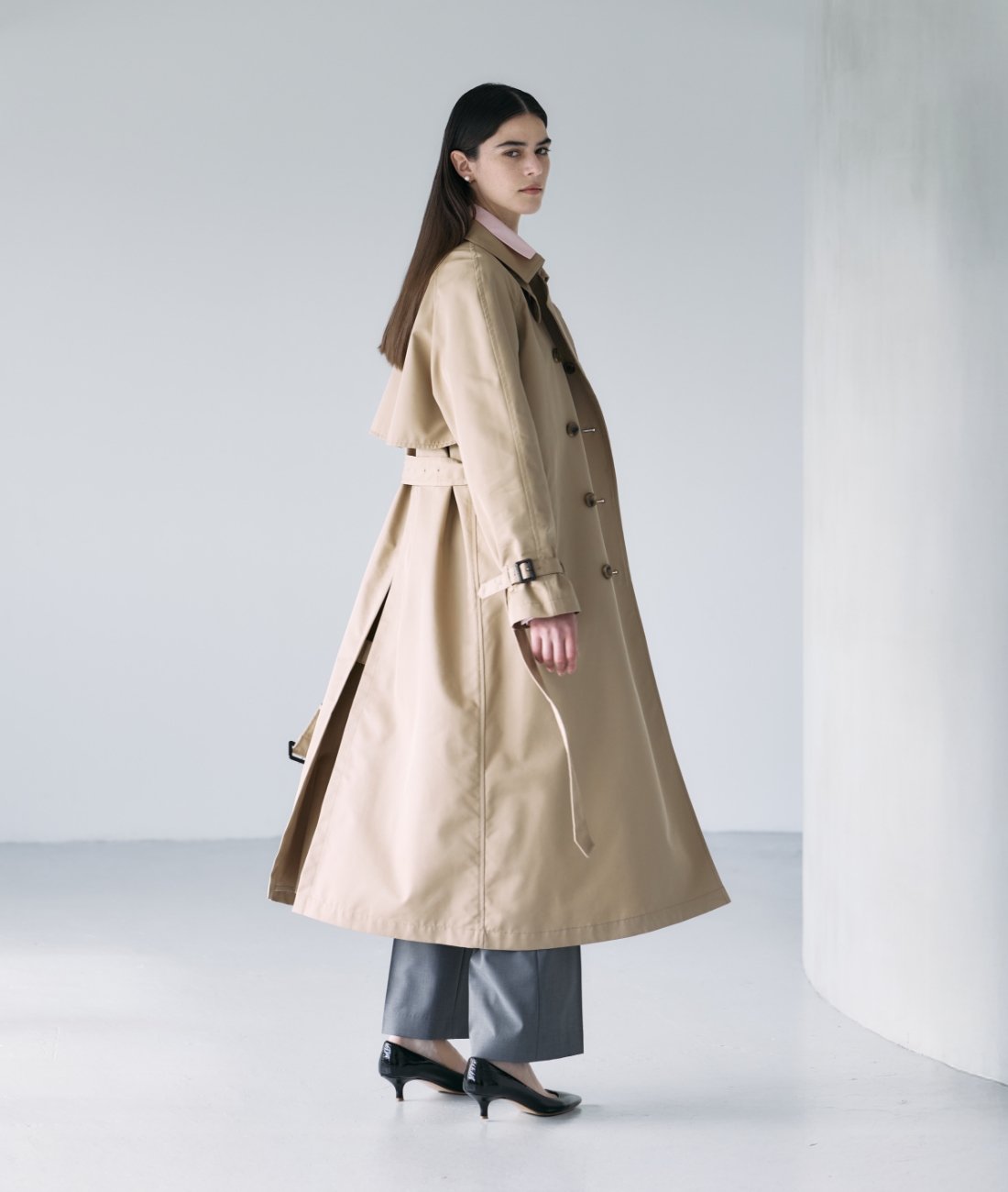 ベージュのロングトレンチコート・ピンクのシャツ・グレーのパンツを着用している女性の画像--4