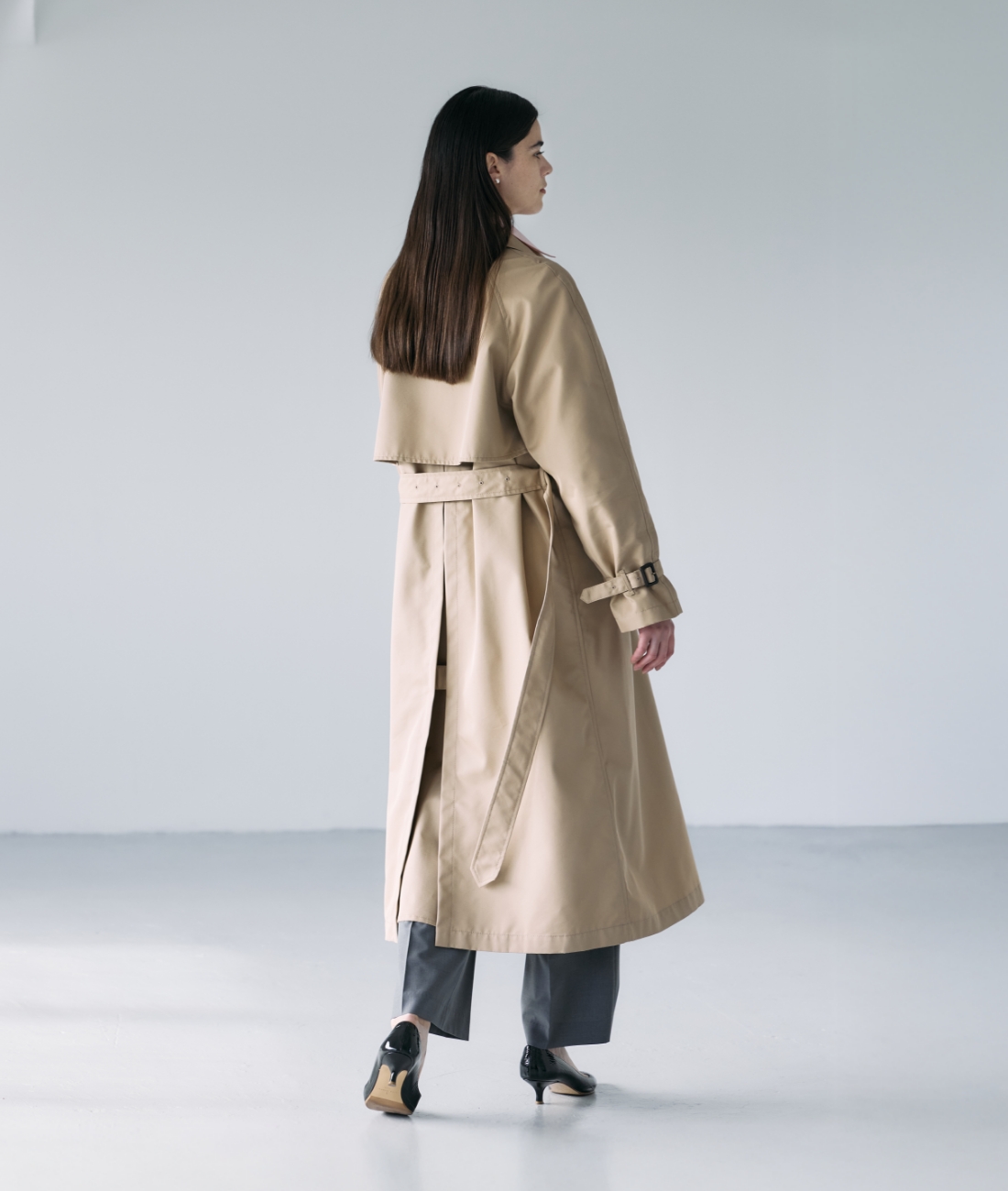 ベージュのロングトレンチコート・ピンクのシャツ・グレーのパンツを着用している女性の画像--5