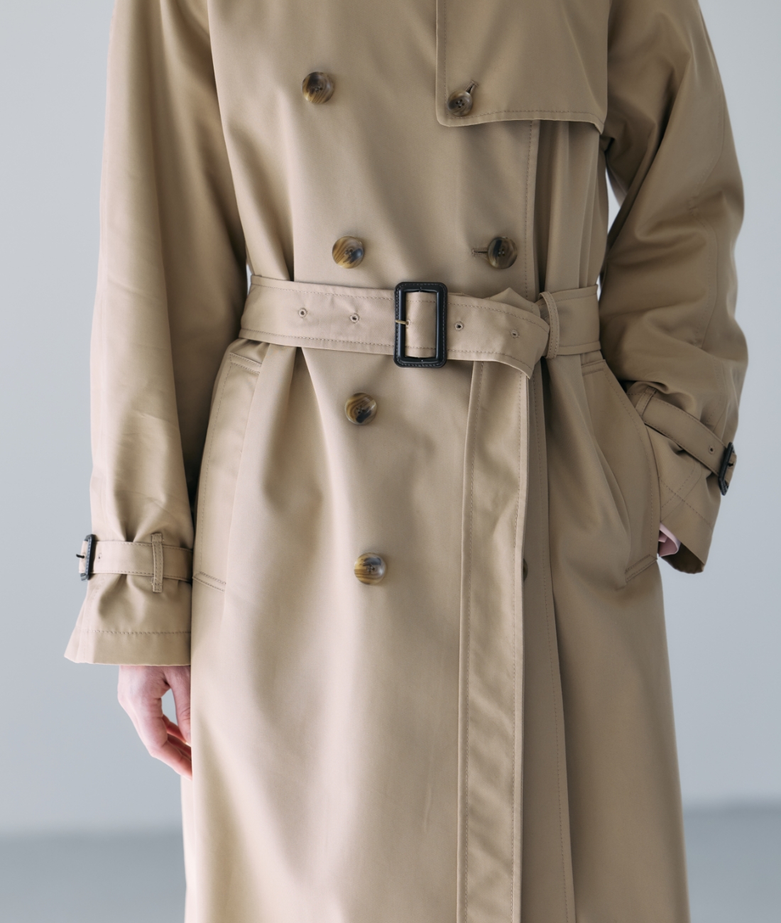 ベージュのロングトレンチコートを着用した女性のアップの画像--2