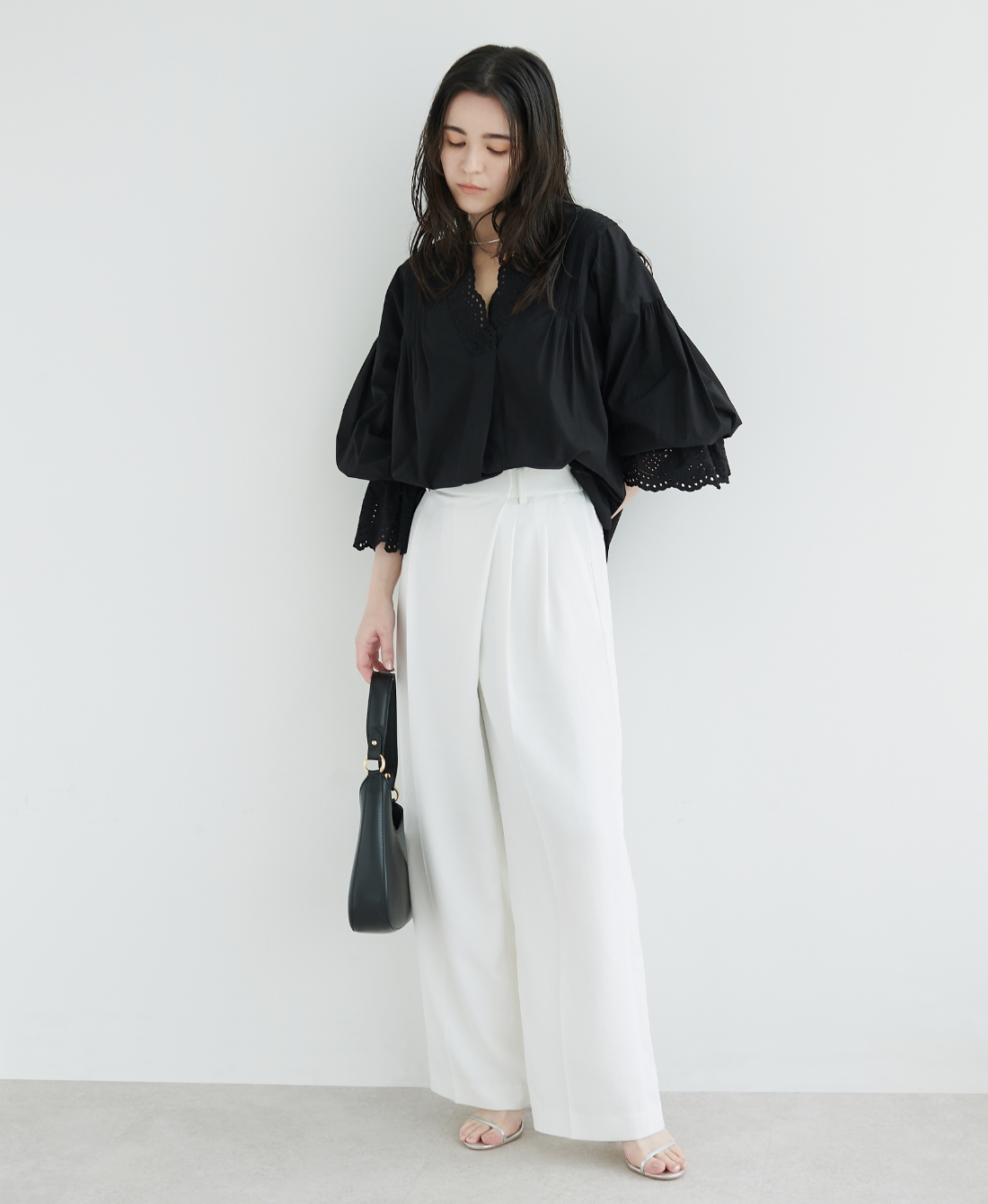 ブラックのブラウス・ホワイトの【トリアセリネン】ラップトラウザーパンツ・ブラックのバッグを着用した女性の画像--2