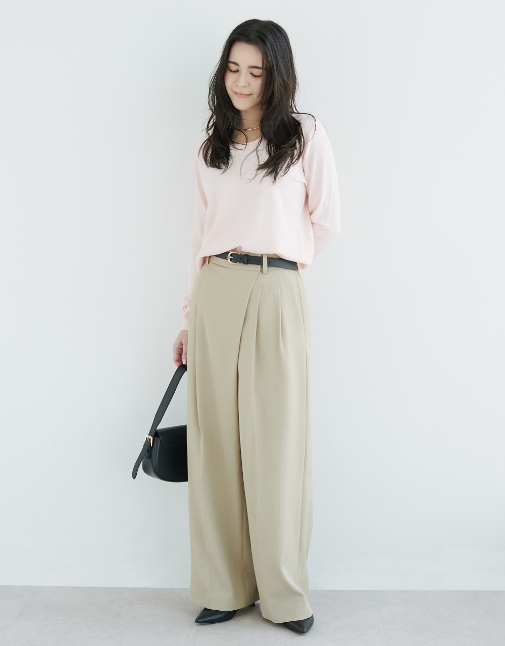 パステルピンクのニット・ベージュの【トリアセリネン】ラップトラウザーパンツ・ブラックのバッグを着用している女性の画像--2