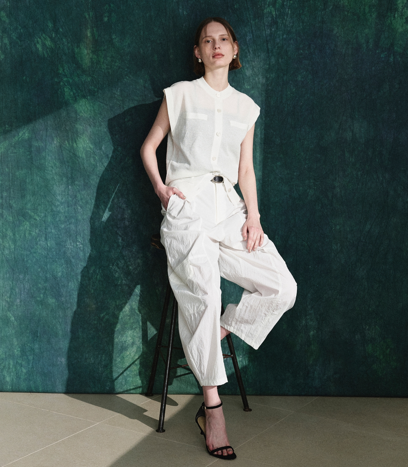 白いニットベストとパンツを着用した女性１