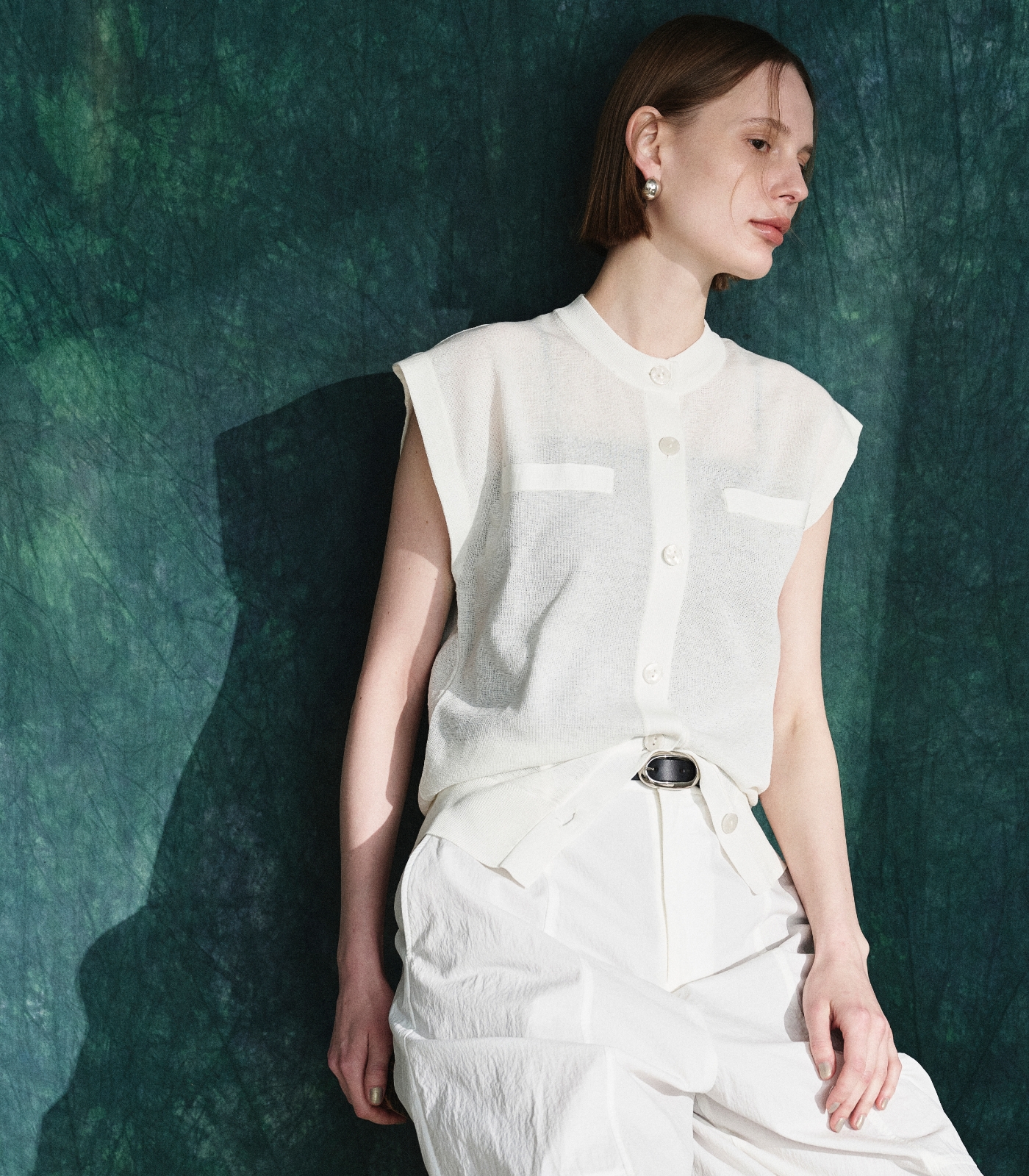 白いニットベストとパンツを着用した女性２