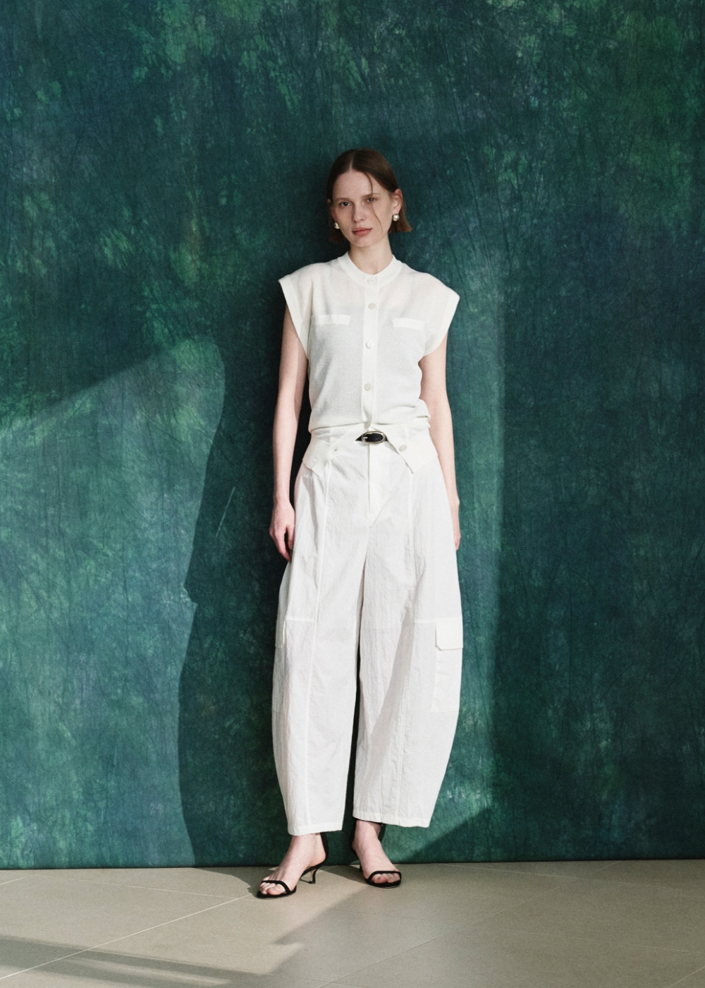 白いニットベストとパンツを着用した女性３