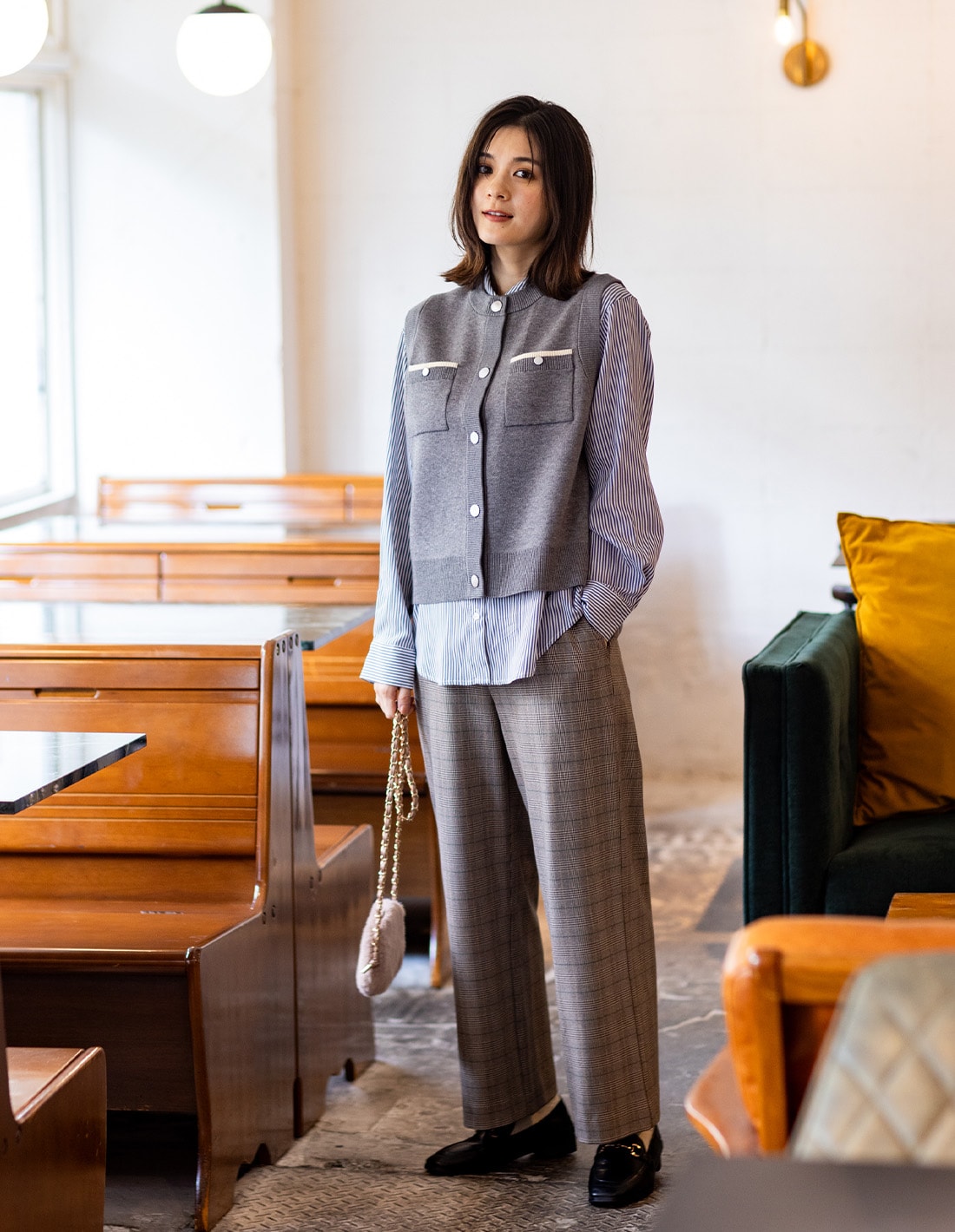 ニットベストとレギュラーカラーシャツとすご楽ワイドパンツを着用した女性１