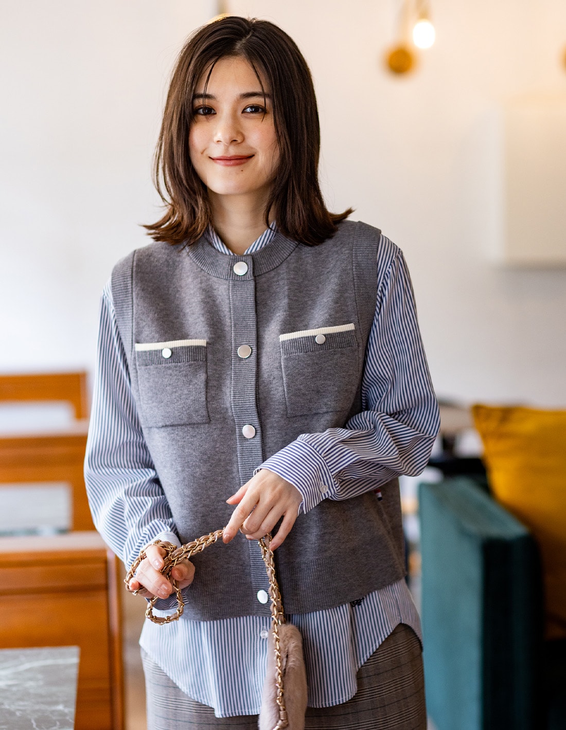 ニットベストとレギュラーカラーシャツとすご楽ワイドパンツを着用した女性２