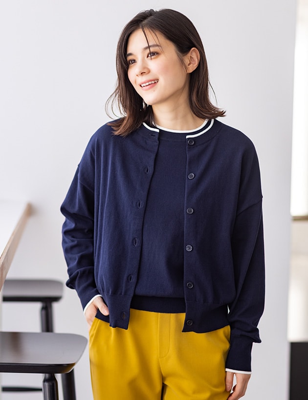 バイカラーニットカーディガンとバイカラーニットプルオーバーとすご楽テーパードパンツを着用した女性２