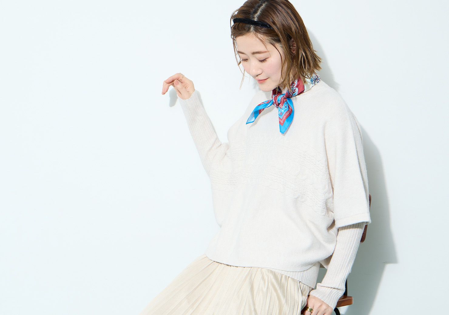 ITEM2　ポンチョアンサンブルニットを着用した女性