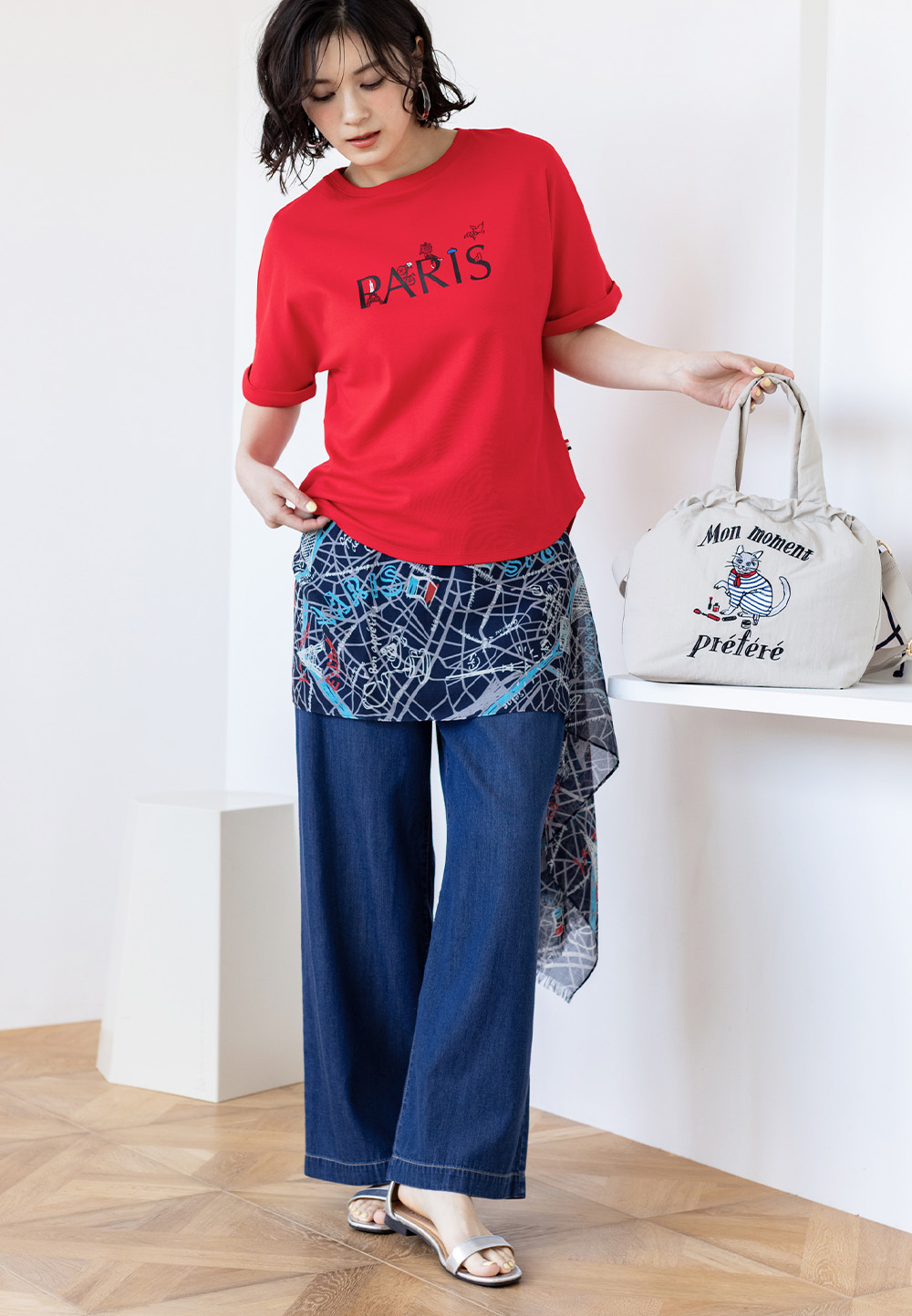 ルージュレッドの【イラストレーターコラボ】PARISロゴプリントTシャツ・プリントストール・ネイビーのデニムワイドパンツを着用した女性--1
