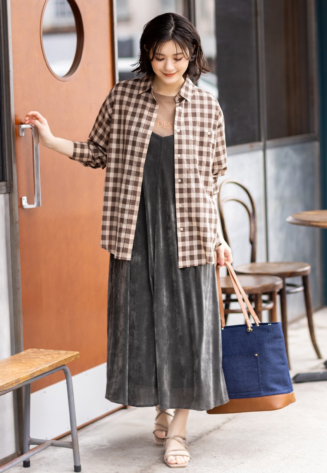 レギュラーカラーシアーチェックシャツとロゴプリントTシャツとベロアキャミソールワンピースを着用した女性１
