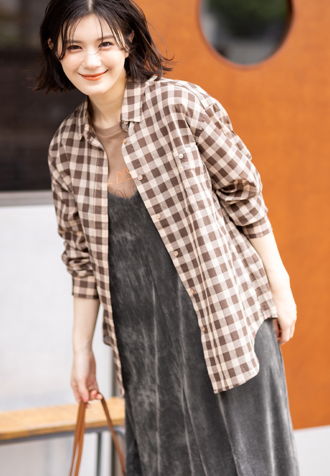 レギュラーカラーシアーチェックシャツとロゴプリントTシャツとベロアキャミソールワンピースを着用した女性２