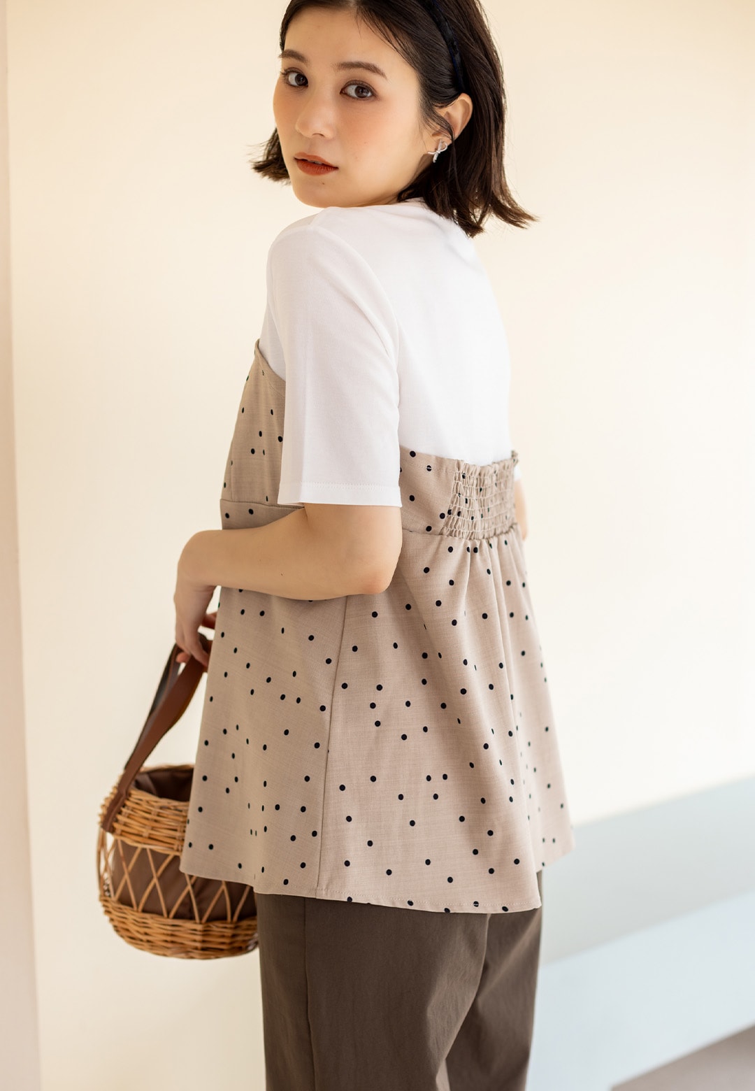 ビスチェレイヤード風Tシャツとストレッチストレートパンツを着用した女性２