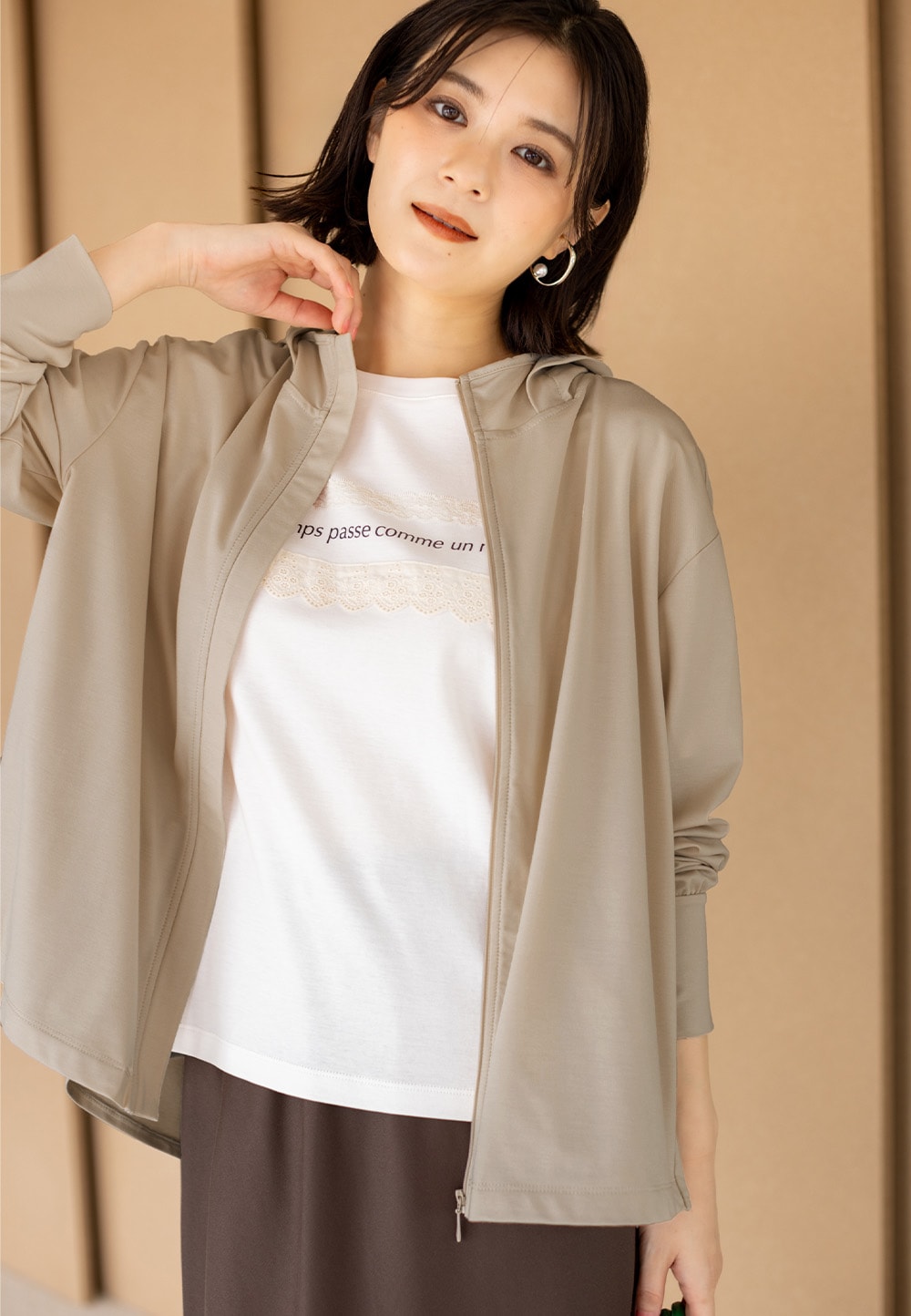 バックタックジップパーカーとレースロゴプリントTシャツとマーメイドラインスカートを着用した女性２