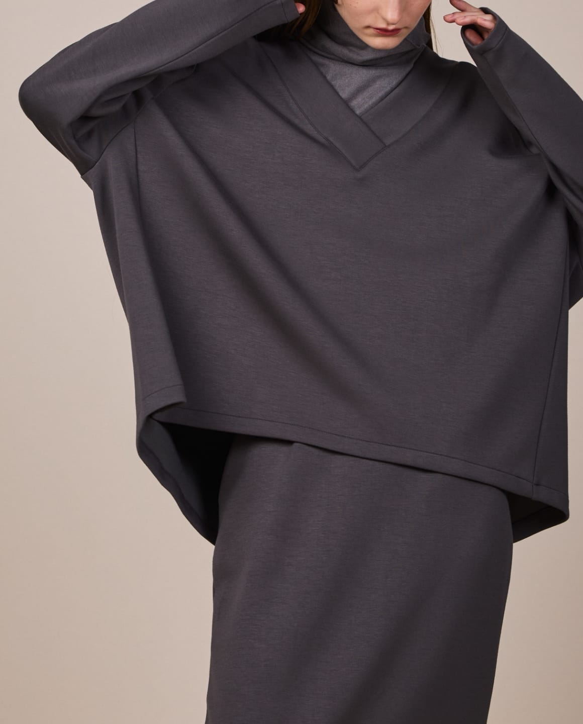 Vネックプルオーバーチャコール、タイトスカートチャコールを着用している女性モデルの腰上写真 modal
