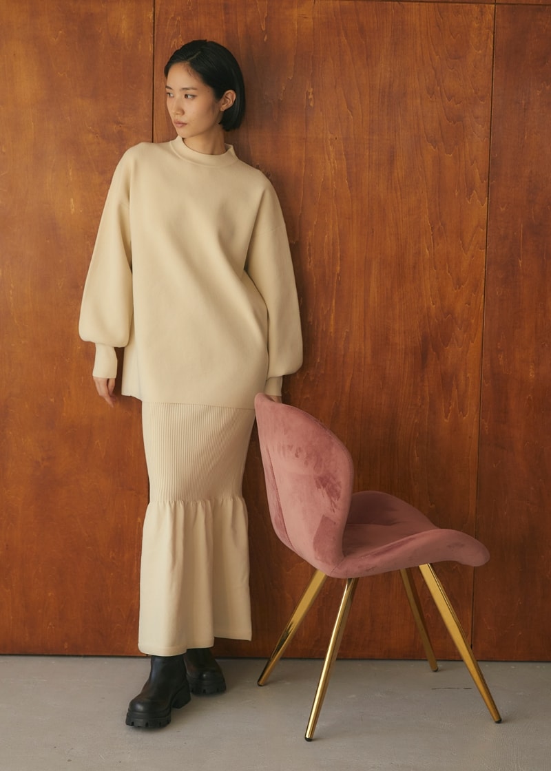 Yuki Ideコラボアイテムセットアップニットを着用して椅子の横に立つ女性の写真