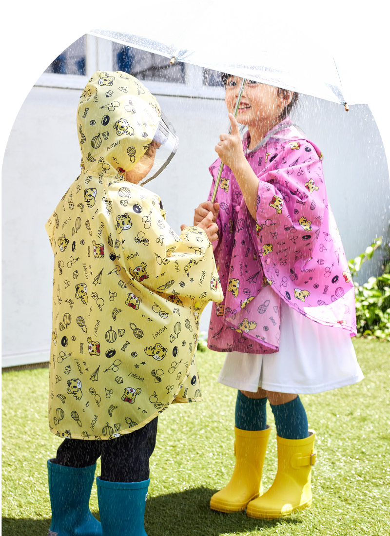 しまじろう　レインポンチョを着用した女の子と男の子が傘の下にいる写真
