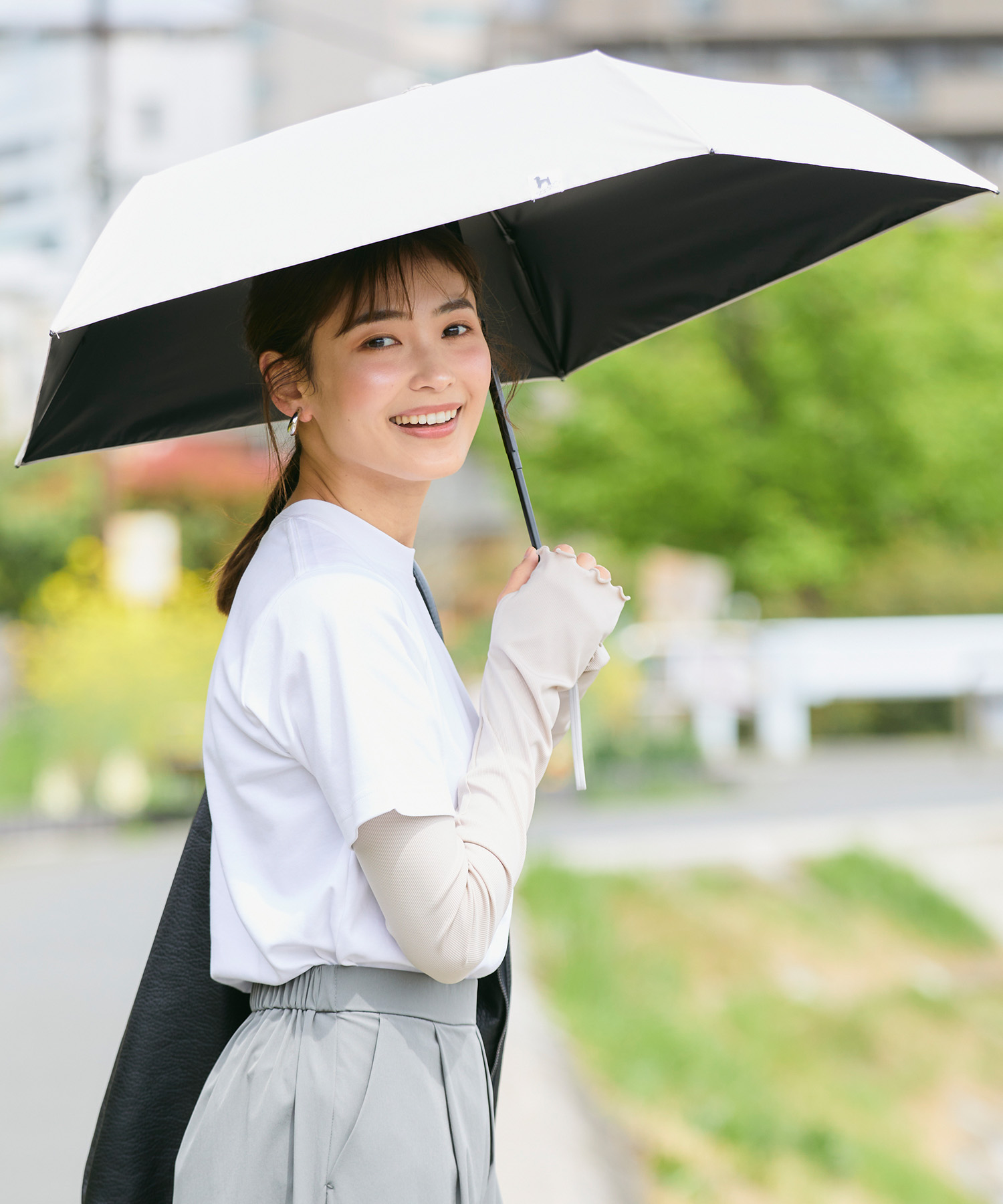 ベースは無地で、ワンポイントのイラストをあしらったシンプルな晴雨兼用の傘。UVカット＆遮光率99.9%以上、UPF50＋、遮熱効果、ワンタッチ開閉式、４色展開。 ▶Go detail