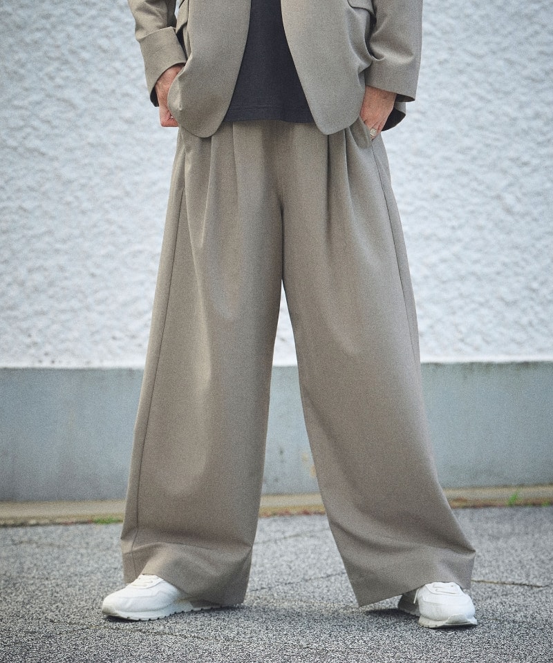 《シワになりにくい》サマ美え リラックスノーカラージャケットと《シワになりにくい》サマ美え ツータックギャザーワイドパンツを着用している女性３