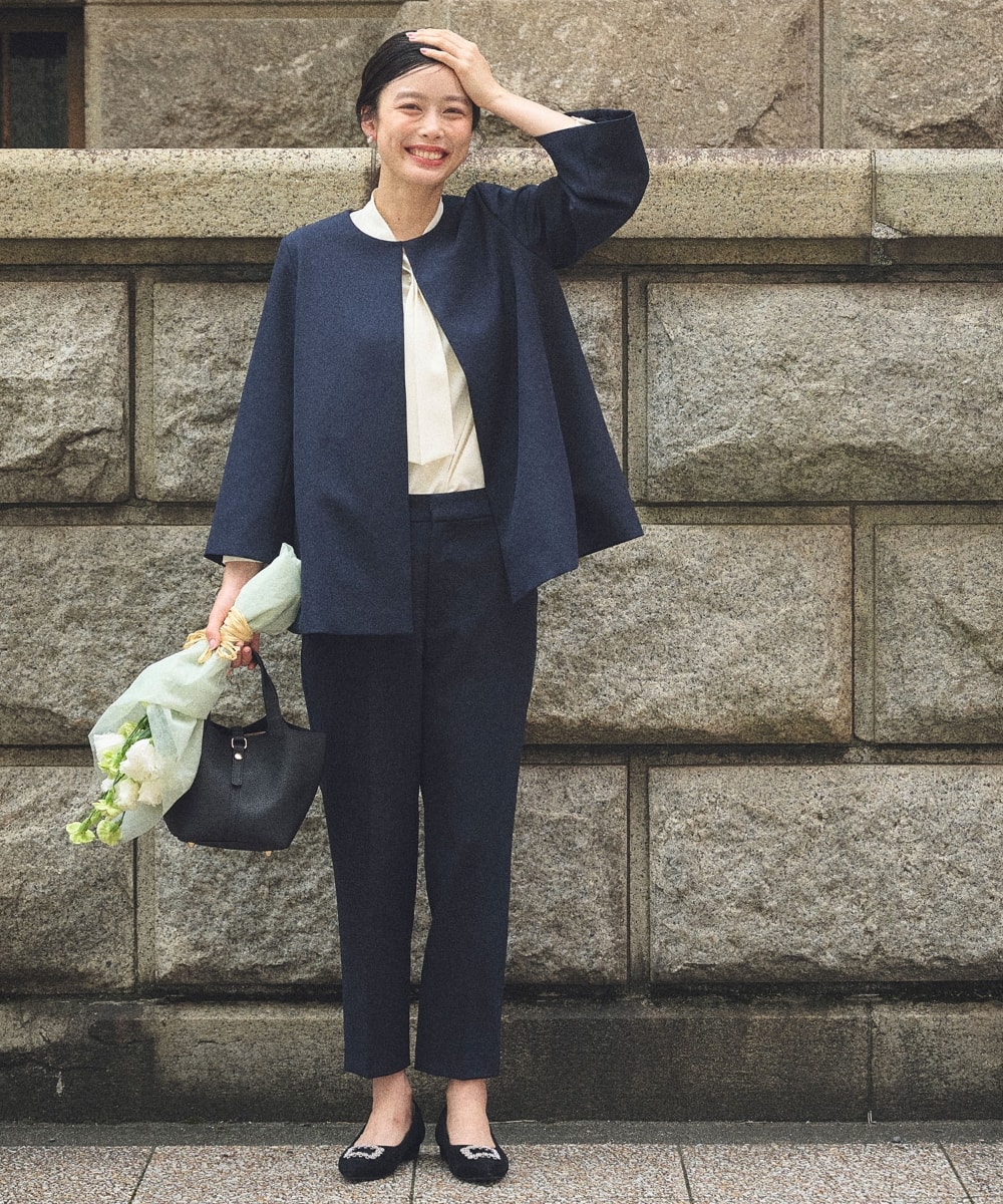 《洗える・シワになりにくい》正解Aラインフレアジャケットと《洗える・シワになりにくい》正解テーパードパンツと《シワになりにくい》シルキーサテンパールボウタイブラウスを着用している女性１