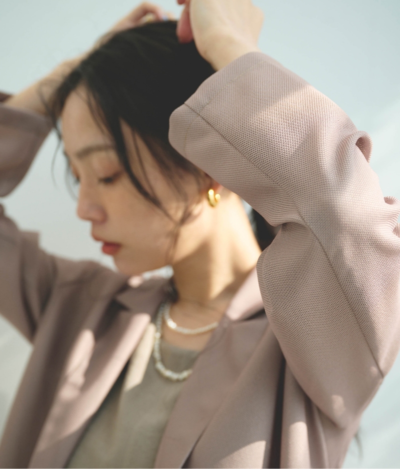 モカブラウンの《洗える》サマ美え 金釦メッシュテーラードダブルジャケット・ベージュの《防シワ》サマナチュラ リネンライクオールインワンを着用した女性のアップの画像
