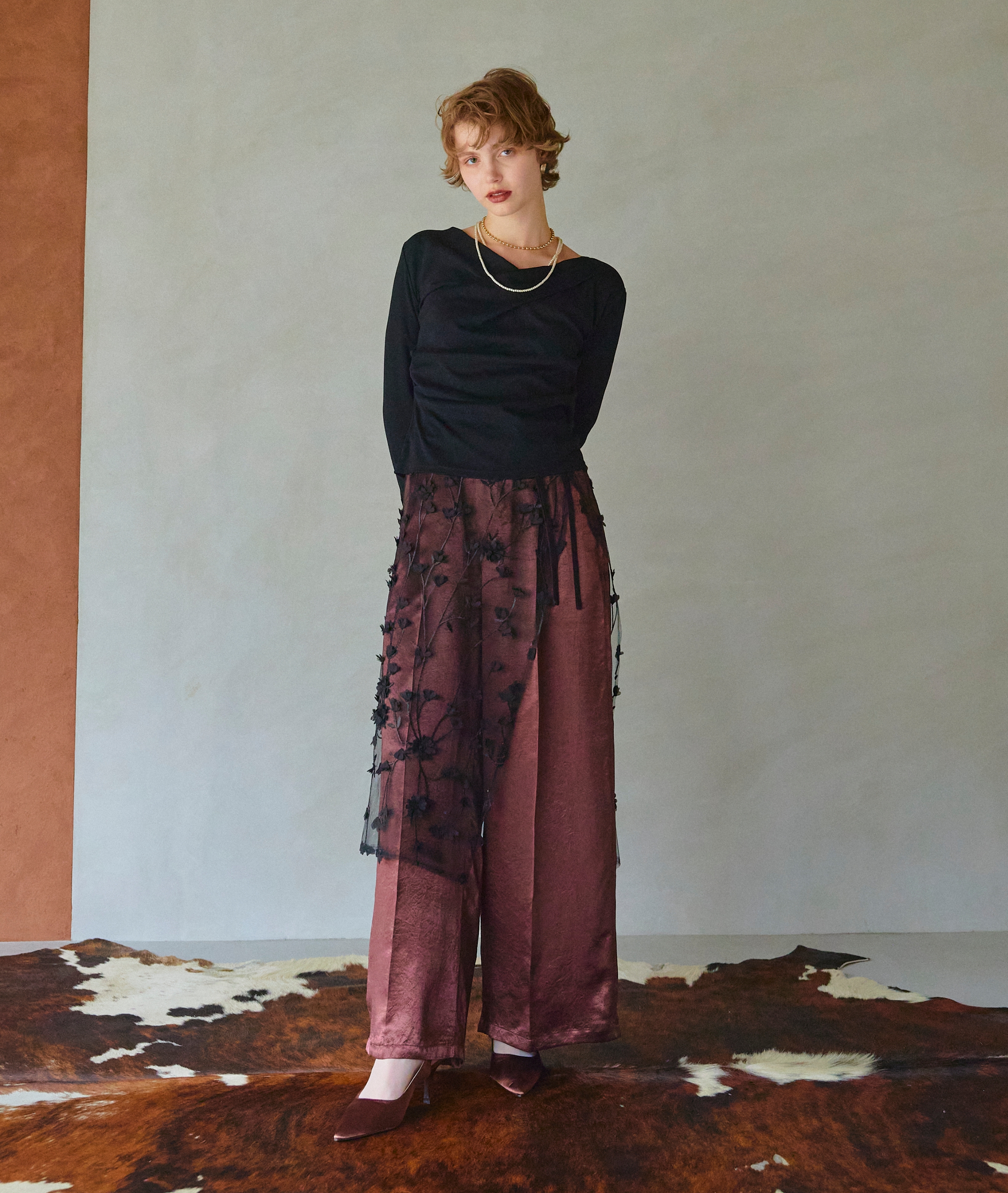 手を後ろに回す黒いTシャツを着た女性