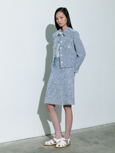 青系のミックス色のJacketとSkirt、Pulloverを着用している女性の画像