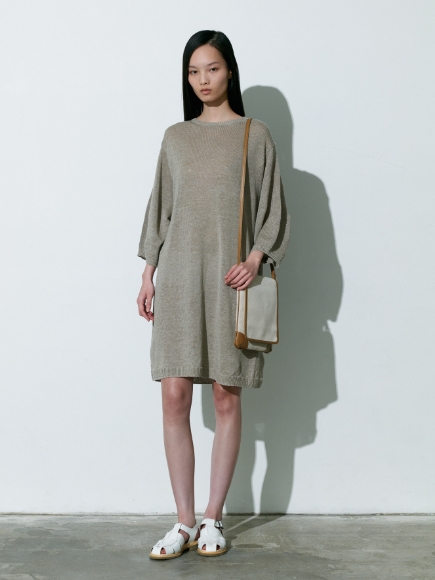 燻んだベージュ色のPullover、キャンバス生地のBagを着用している女性の画像