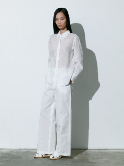 白色のブラウスとズボンを着用している女性の画像