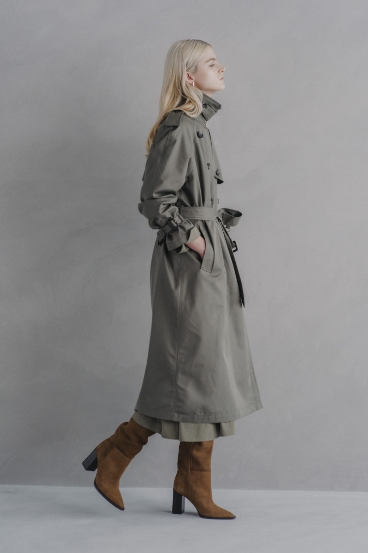 ロングトレンチコートとシルキーツイルワンピースを着用した女性の写真