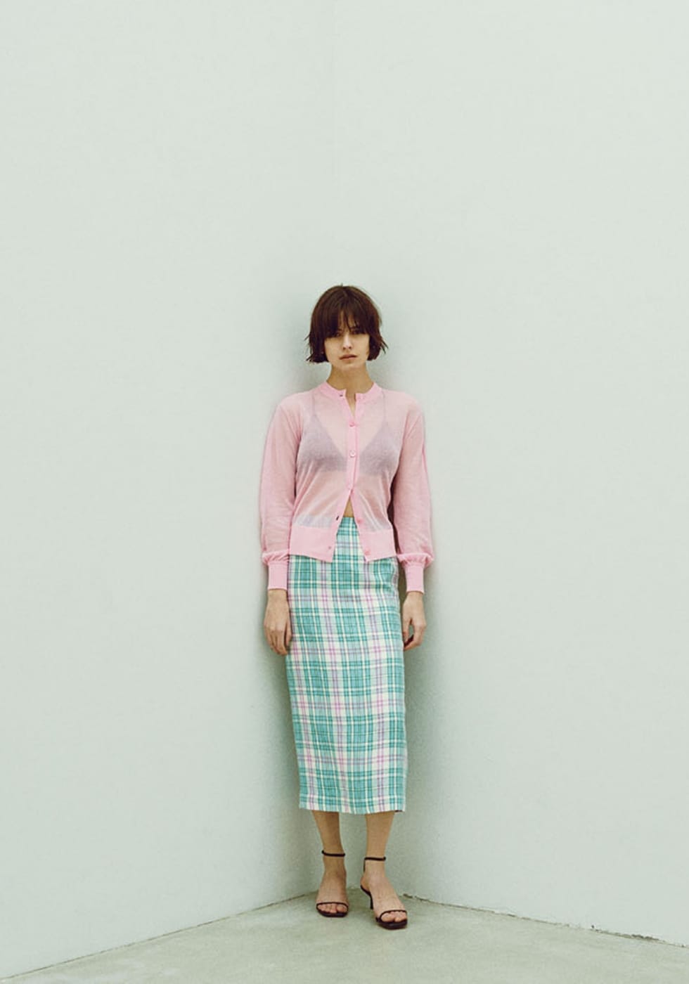 シアーニット カーディガン、ペンシル スカートを着用した女性の写真-1