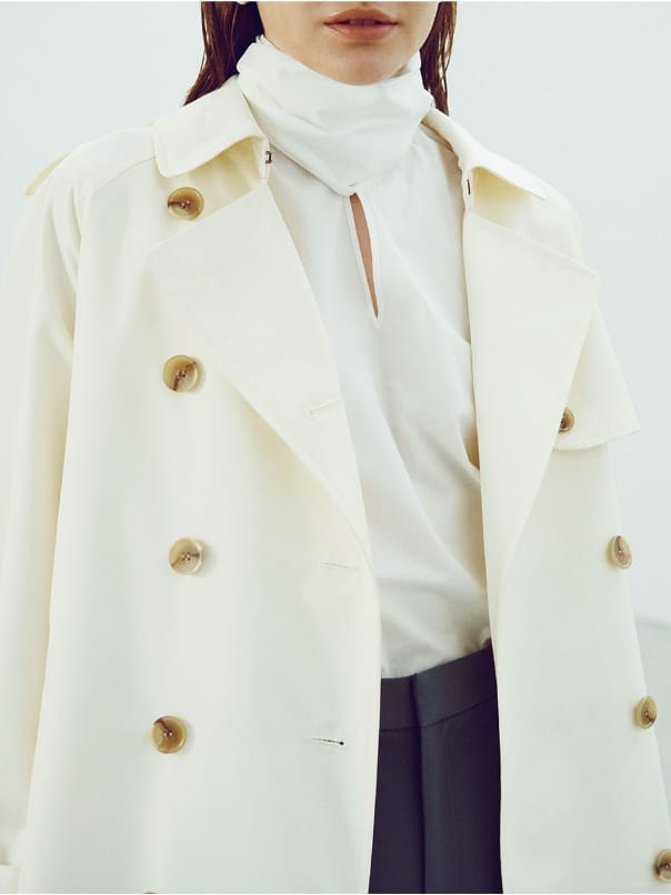 ロングトレンチ コート、タイプライターボウタイ ブラウス、ダブルクロス パンツを着用した女性の写真-2