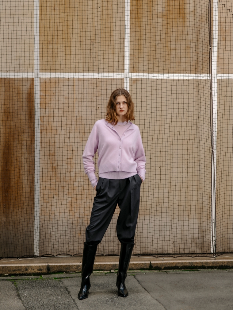 ピンクのカーディガン・ピンクのニット・ブラックの<FITTING CAMPAIGN対象商品>ウォッシャブル2タックルーミーパンツ【CLEAN MOTION】を着用した女性の画像